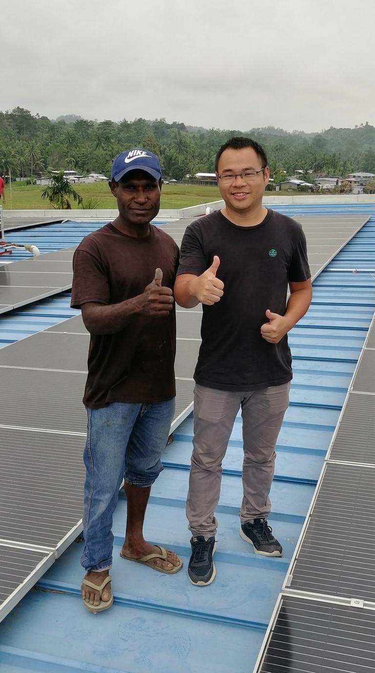 Commercial Rooftop Solar Installation & Technical Support SNADI solar engineer and local installer giving thumbs up on a blue corrugated metal rooftop during a commercial solar panel installation project.