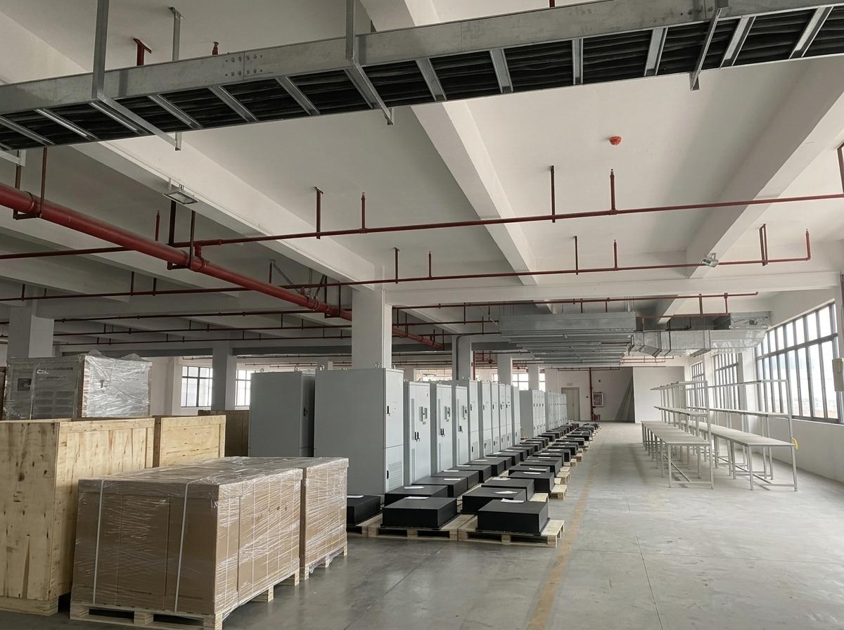 Industrial-Grade Commercial Solar Storage System Manufacturing Rows of heavy-duty industrial ESS cabinets and high-capacity central inverters on the production floor of a commercial solar storage system factory.