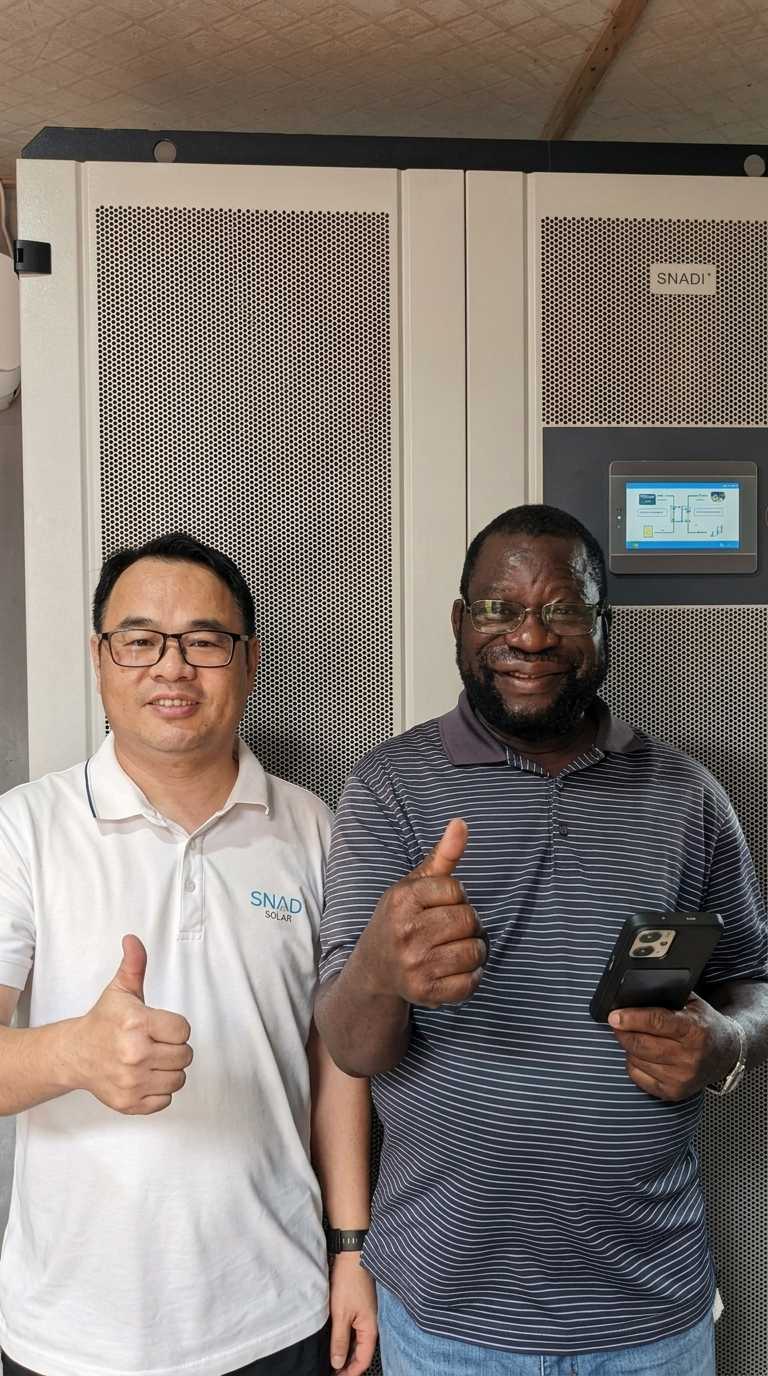 Industrial Solar Storage Systems (ESS) & C&I Energy Solutions SNADI team member and an international client standing in front of a heavy-duty industrial SNADI solar storage system cabinet, signaling a successful deployment.